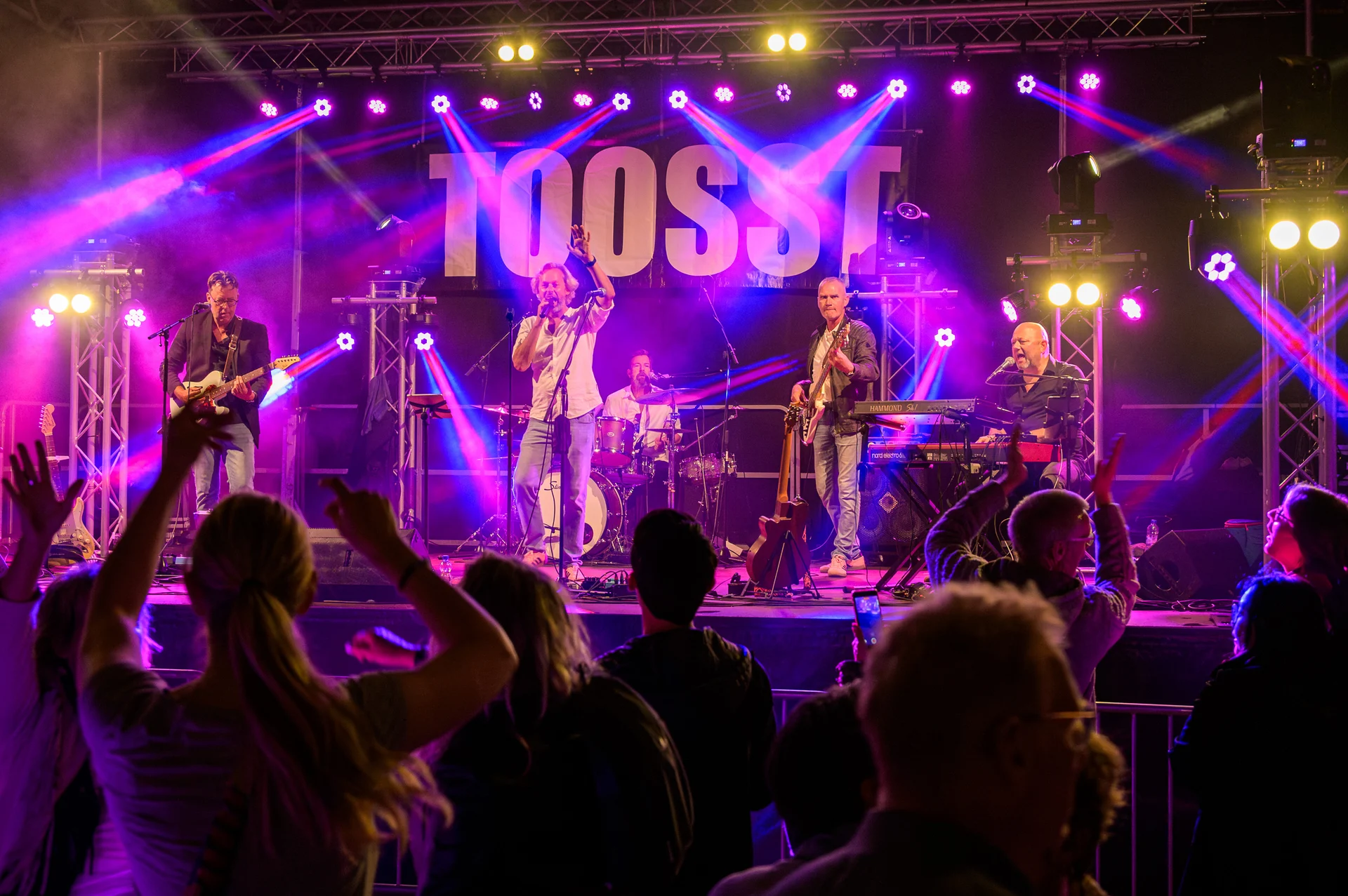 De vijf bandleden van TOOSST live op het podium